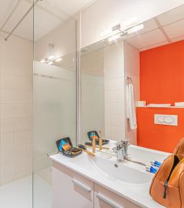 a bathroom with a sink and a mirror at Montempô Apparthôtel Toulouse Balma in Toulouse