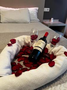 una botella de vino y dos copas de rosas rojas en Hello Villarreal Suites, en Villareal