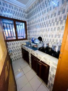 a kitchen with a counter top with pots and pans at As résidence meublée in Ouagadougou