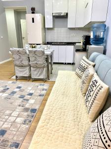 a living room with a couch and a kitchen at 3-x комнатная квартира в ЖК Евразия в самом сердце Алматы! in Almaty