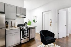 a kitchen with a stove and a black chair at 91-2A Stylish 3BR 2Bth with W D in New York