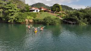 a group of people on paddle boards in the water at Casa Caletas Boutique Hotel in Puerto Coyote