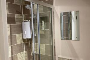 La salle de bains est pourvue d'une douche avec une porte en verre. dans l'établissement Green Glades Annex by StayStaycations, à Bristol