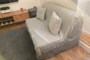 biała kanapa z 2 poduszkami w salonie w obiekcie Green Glades Annex by StayStaycations w Bristolu