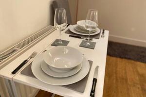 a table with plates and wine glasses on it at Green Glades Annex by StayStaycations in Bristol
