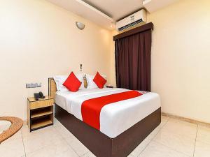 1 dormitorio con 1 cama grande con almohadas rojas en OYO Royal Plaza Residence -3, en Ras al Khaimah
