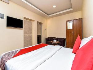 1 dormitorio con 1 cama grande con almohadas rojas en OYO Royal Plaza Residence -3, en Ras al Khaimah