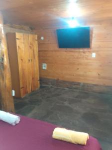 a room with a bed and a tv on a wall at CABAÑAS EL PALENQUE in Esquel