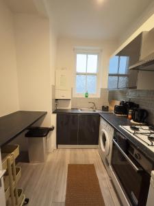 a kitchen with a sink and a washing machine at The Chalton Funk-in Kings Cross (ZONE 1)!!! in London