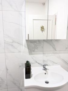 La salle de bains blanche est pourvue d'un lavabo et d'un miroir. dans l'établissement The Chalton Funk-in Kings Cross (ZONE 1)!!!, à Londres
