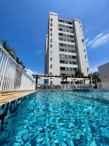 uma grande piscina em frente a um edifício em O seu apê na praia, 2 dormitórios, com piscina em Barra Velha