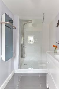 a white bathroom with a shower and a sink at Spacious coastal cottage close to beach - Bailey Cottage in Deal
