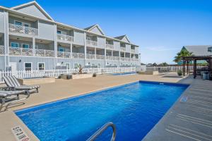 a swimming pool in front of a large building at Beach Life in Port Aransas