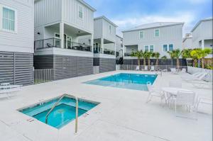 a swimming pool with a table and chairs next to a building at Lost Dunes #B in Gulf Shores