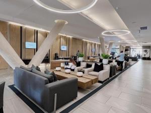 a lobby with couches and tables in a building at The Capital Sandton Luxury apartment with free pool, gym, spa and Netflix in Johannesburg