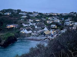 een groep huizen op een heuvel naast een rivier bij Cadgwith Cove Inn in Cadgwith