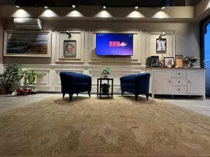 a waiting room with two blue chairs and a tv at Plus Hotel & Private Transportation İstanbul Airport-By Loft in Arnavutköy