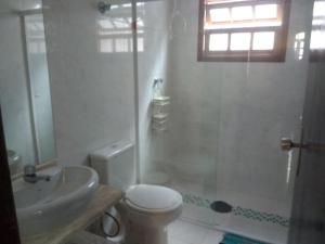 ein Bad mit einem WC, einer Dusche und einem Waschbecken in der Unterkunft Casa com piscina in Bertioga