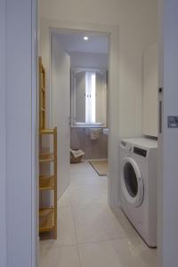 a white laundry room with a washer and dryer at Attic with terrace on Conca d'oro in Rome