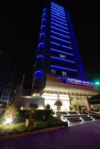 a tall building with blue lights on it at night at Gulf Oasis Hotel Apartments in Dubai