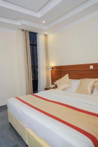 een groot bed in een kamer met een raam bij Standard Single Room At Amikus Hotel in Gasanze +1 foto