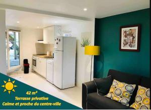 eine Küche mit einem Kühlschrank und einem Sofa in einem Zimmer in der Unterkunft Superbe T2 avec Terrasse face au parc des fontaines in Toulouse