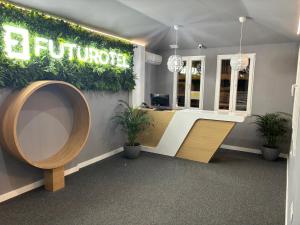 an office with a reception desk with plants on the wall at Futurotel Granada Dreams in Granada