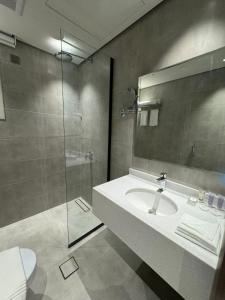 a bathroom with a sink and a shower at الحزم للشقق الفندقية - الرياض - العليا in Riyadh
