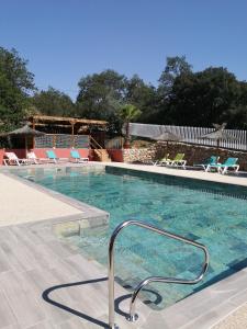 a swimming pool with blue and white chairs in it at Camping Mas Llinas in Le Boulou