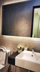 y baño con lavabo blanco y espejo. en Romantic Sea View Room @ Urban Suites, Jelutong, en Jelutong