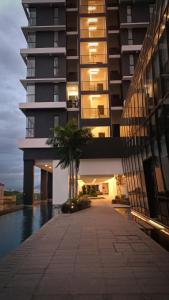 ein hohes Gebäude mit einer Palme davor in der Unterkunft Romantic Sea View Room @ Urban Suites, Jelutong in Jelutong