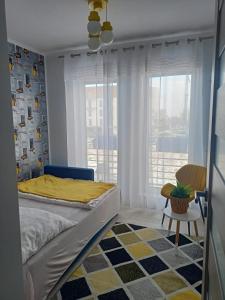 a bedroom with a bed and a large window at Apartament KLARA in Rumia