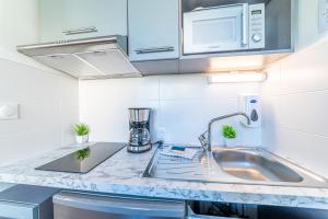 图卢兹Montempô + Apparthôtel Toulouse Cité Internationale的配有水槽和微波炉的厨房