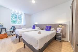 图卢兹Montempô + Apparthôtel Toulouse Cité Internationale的有两张床和一张书桌的房间