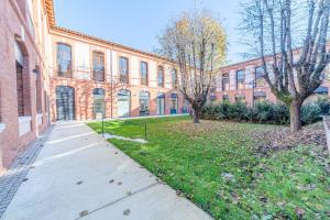图卢兹Montempô + Apparthôtel Toulouse Cité Internationale的砖楼前空的路边