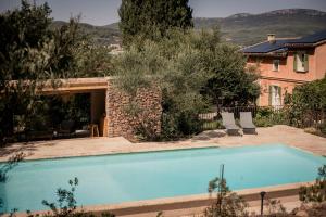 una piscina con 2 sillas junto a una casa en Les Hauts de Diane, CUERS var, en Cuers