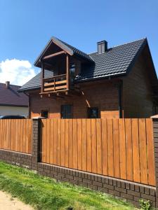 a wooden fence in front of a house at Słoneczna Polana nad Biebrzą in Goniadz