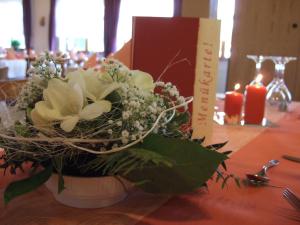 un bouquet de fleurs dans un vase sur une table dans l'établissement Gasthaus Debelius Beltershausen, à Marbourg