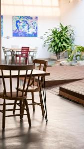 een houten tafel en stoelen naast een tafel en stoelen bij Hostal Casa Mosaiko Nutibara Laureles in Medellín