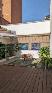 patio con terrazza in legno e tavolo di Hostal Boutique Casa Mosaiko Nutibara a Medellín