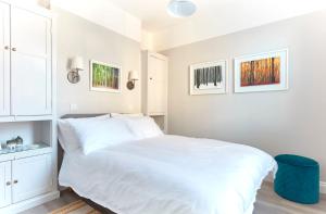 - une chambre blanche avec un lit et un tabouret bleu dans l'établissement Spacious beach front apartment with stunning sea views, à Deal