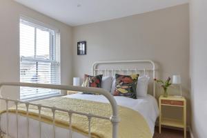um quarto branco com uma cama e uma janela em Sunbeam Cottage em Deal