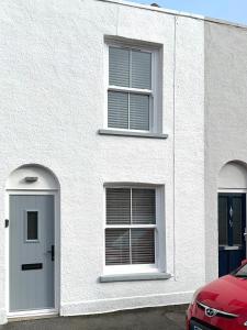 um edifício branco com duas janelas e uma porta em Sunbeam Cottage em Deal
