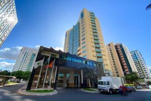 a truck parked in front of a building with tall buildings at Hotel Lets Ideia Brasília - Ozped Flats in Brasília