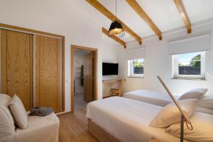um quarto de hotel com duas camas e uma televisão em Quinta da Bornacha - Casa A em Vila Nova de Cacela