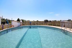 una gran piscina con una valla de madera en Quinta da Bornacha - Casa A en Vila Nova de Cacela