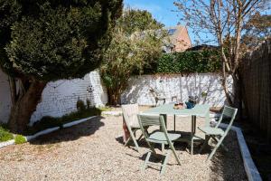 a table and chairs in a backyard with a fence at The Deal Abode - luxury self catering retreat in Deal