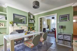 a living room with green walls and a white table and chairs at The Deal Abode - luxury self catering retreat in Deal