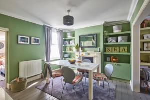 a dining room with green walls and a table and chairs at The Deal Abode - luxury self catering retreat in Deal