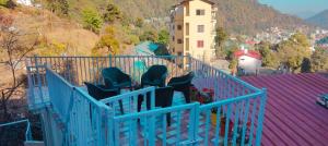 grupa krzeseł siedzących na balkonie w obiekcie Alan's 3BHK w mieście Nainital